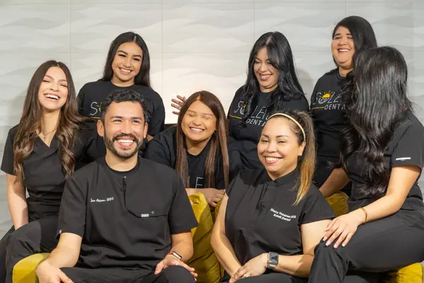 Soleil Dental team laughing on their yellow couch